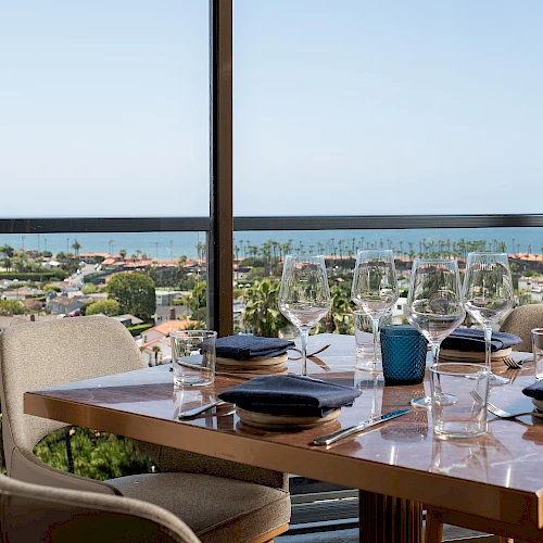 A set dining table overlooks the coast at one of the best La Jolla restaurants with ocean view.